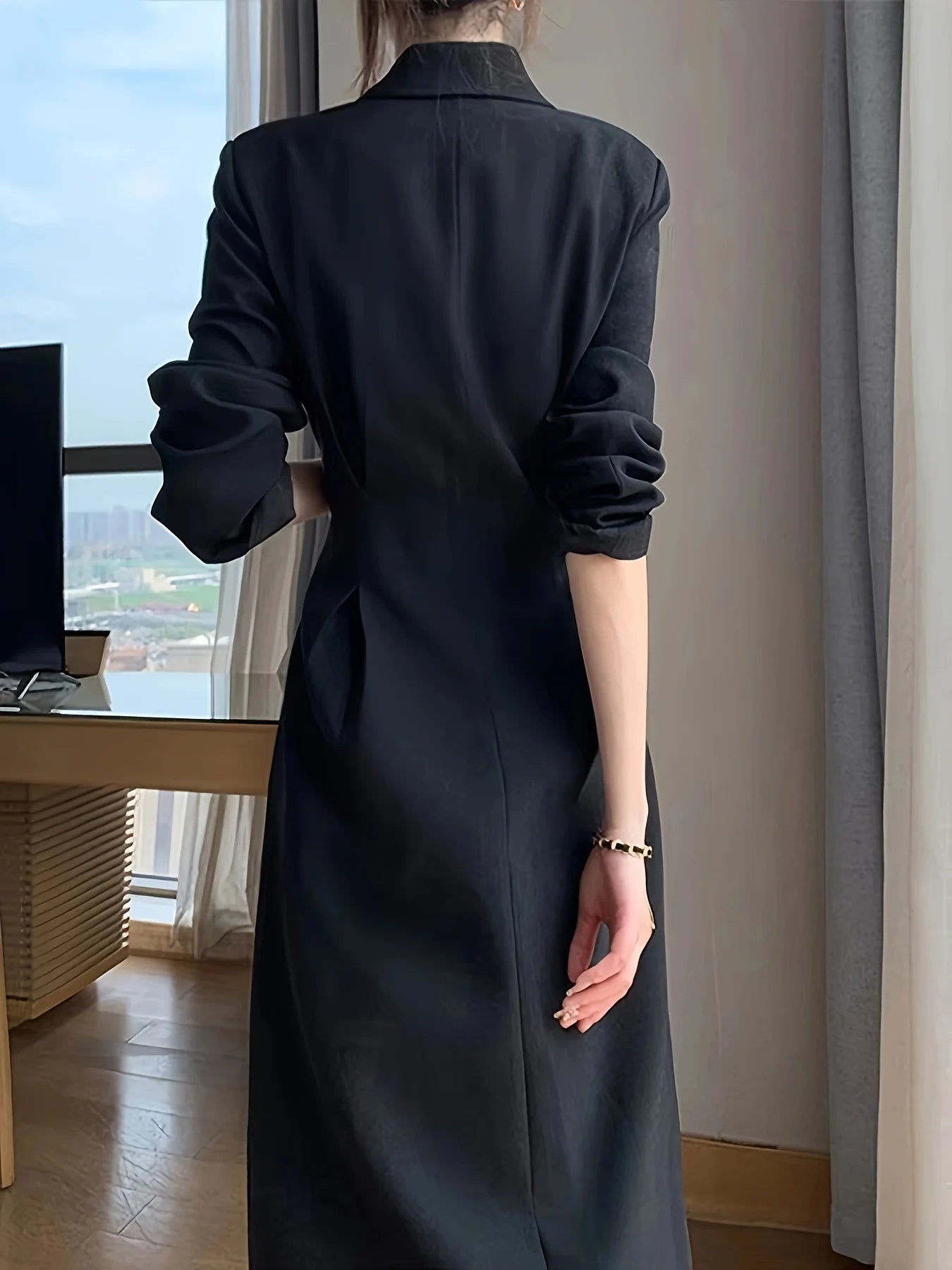 A black long-sleeved dress that is slimming and elegant, with a suit-style design.